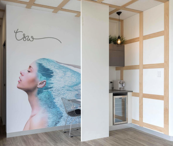 Total Skin Wellness - Mural of a serene lady adorning a wooden interior, creating a peaceful and coastal ambiance at the practice designed by Consilo