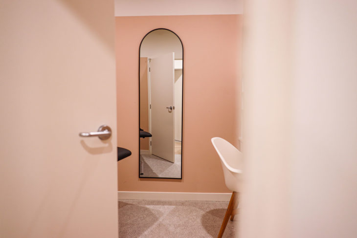 Refine Physiotherapy - Black Curved Arch Wall Mirror in a Stylish Interior Setting