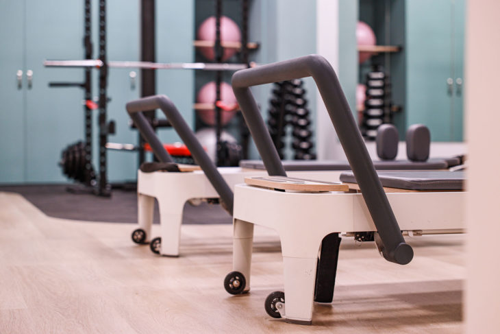 Refine Physiotherapy - Close Ups of Reformer Beds for Pilates with Gym Equipments on the Background