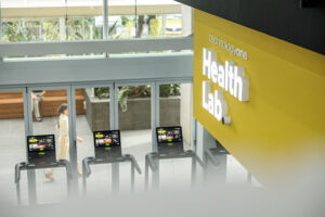 Yellow sign of Technology One Health Lab with Treadmills, showcasing cutting-edge technology in a modern gym facility