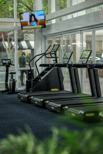 Technology One Brisbane - Modern and fully equipped gym at Technology One, promoting employee fitness and wellbeing, with a range of cardio and strength training equipment, functional fitness accessories, and a TV for added entertainment
