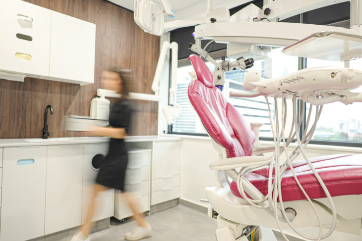 A Woman Is Running Past a Dental Chair in a Dental Office